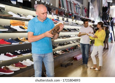 Adult Customers Choosing Sneakers In Streetwear Store