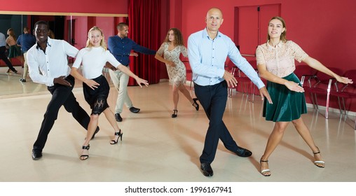 Adult Dancing Couples Enjoying Rhythmic Tap Dance In Dance Studio..