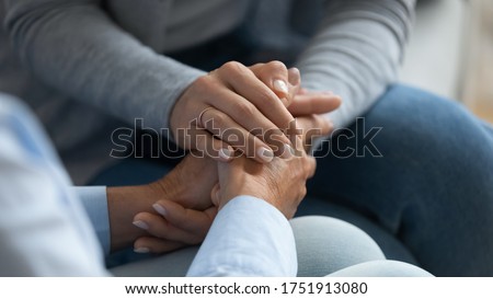 Adult daughter comforting old mom strokes holds her hand close up view. Strong connection confidential conversation, empathy and mercy, support in hard life period, be near sharing heart pain concept