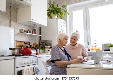 Adult Daughter Teaching Her Elderly Mother To Use Laptop