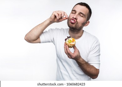 Adult is divouring sweet creamy dessert. He is enjoying the process of eating it. Isolated on white background.