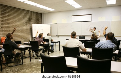 Adult Education Class Raising Their Hands To Answer A Question.