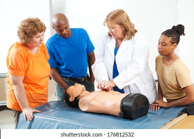 Adult education students learning CPR and first aid from a doctor or nurse.  