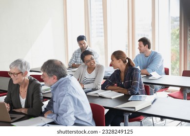 Adult education students working in pairs in classroom - Shutterstock ID 2328249125