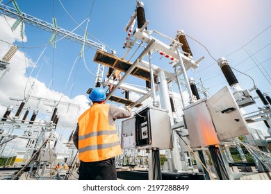 Adult electrical engineer inspect the electrical systems at the equipment control cabinet. Installation of modern electrical station