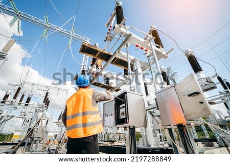Adult electrical engineer inspect the electrical systems at the equipment control cabinet. Installation of modern electrical station