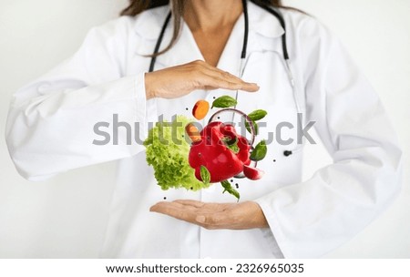 Adult european woman doctor nutritionist in white coat hold organic fruits , vegetables in hands on white background, studio. Healthcare, proper nutrition recommendation, medical diet and treatment