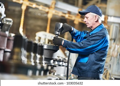 adult experienced industrial worker during heavy industry machinery assembling on production line manufacturing workshop