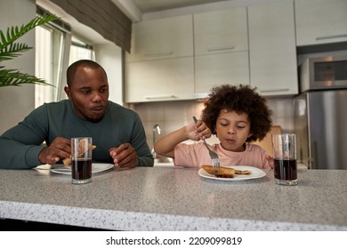 Adult Father And Little Son Having Lunch Or Breakfast With Cola And Pizza At Table At Home Kitchen. Unhealthy Eating. Young Black Family Lifestyle And Relationship. Fatherhood And Parenting