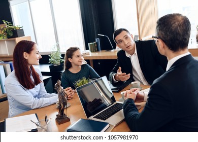 Adult father, red head mother and little smiling daughter are sitting in lawyer's office. Family in office of family lawyer.