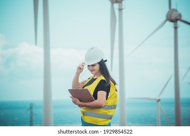 adult female engineer supervises solar panels and windmills in a renewable energy complex - Shutterstock ID 1929854522