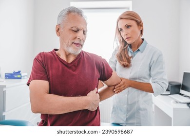 Adult female orthopedist examining patient's back in clinic hospital. Spinal injury treatment. Reflexology concept for elderly patients. Geriatrics - Powered by Shutterstock