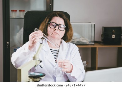 Adult female researcher studying insect behavior in a test tube. Research Laboratory. Study of insects. - Powered by Shutterstock