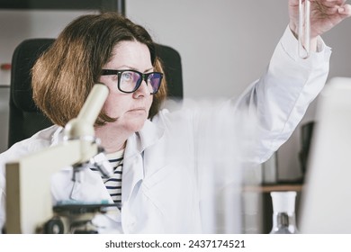 Adult female researcher studying insect behavior in a test tube. Research Laboratory. Biology of Living Beings. - Powered by Shutterstock