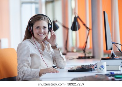 Adult female secretary with headphones doing customer service in a callcenter Foto Stock