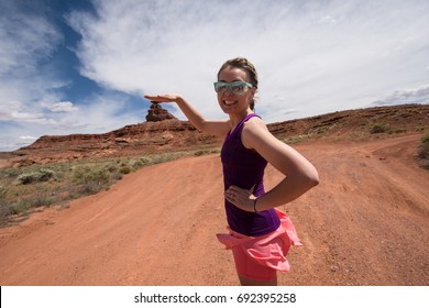 An Adult Female Shows A Forced Perspective View Of Mexican Hat Rock Formation In The Utah Desert By Pretending To Put Her Hand On Top Of The Formation