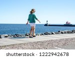 Adult female takes a relaxing stroll on Duluth Canal Park Lakewalk along Lake Superior. Lighthouses in background