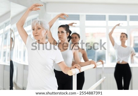 Similar – Image, Stock Photo A female trainer teaching a student how to do push-ups correctly.Outdoor sports in urban environment