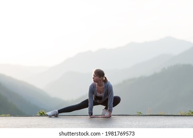 Adult Female Workout Before Fitness Training Session At The Top Of The Mountain. Woman Warming Up Outdoors. 