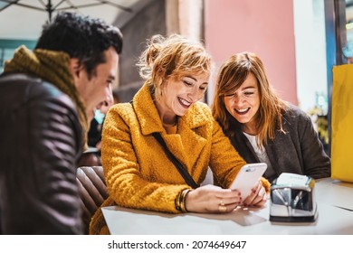 Adult friends having fun watching content on smartphone screen sitting at cafe - Group of 40s people using social media application and surfing online
