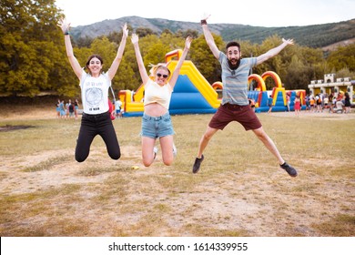 Adult friends jumping and having fun near the bouncy castle in the countryside. Fun concept. - Powered by Shutterstock