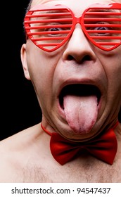 Adult Gay Man Sticking Out Tongue Over Black Background