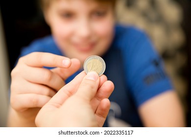 Adult  Giving Coin To A Child As Saving Money Concept. Children's Financial Education, Financial Literacy. Payment For Duties Performed.