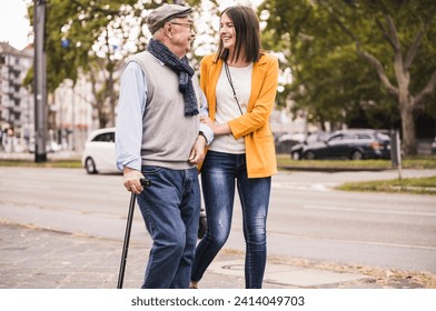 Adult granddaughter assisting her grandfather strolling with walking stick - Powered by Shutterstock