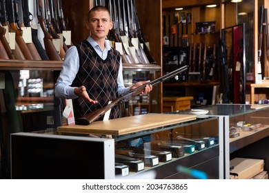 Adult Gunshop Seller With A Rare Collectible Hunting Rifle In His Hands