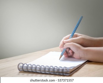 Adult Hand Holding Child Hand To Writing On Notebook.Concept Of Learning,teaching And Practice