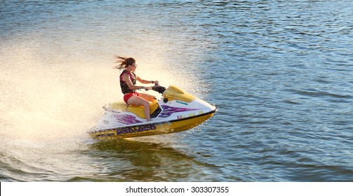 Adult Having Fun Jumping A Wave Riding Yellow And White Jet Ski In California Ocean