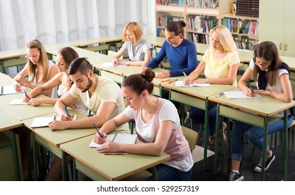 Adult Highschool Students Learning In Classroom At Their Desks