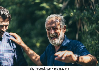 An Adult Hipster Son And Senior Father At Home, Talking.