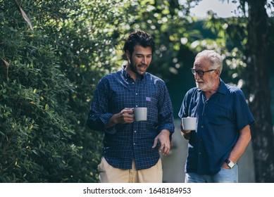 An Adult Hipster Son And Senior Father At Home, Talking.