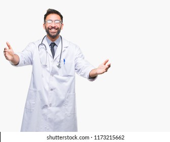 Adult Hispanic Doctor Man Over Isolated Background Looking At The Camera Smiling With Open Arms For Hug. Cheerful Expression Embracing Happiness.