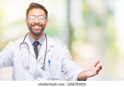 Adult Hispanic Doctor Man Over Isolated Background Looking At The Camera Smiling With Open Arms For Hug. Cheerful Expression Embracing Happiness.