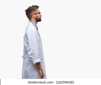 Adult Hispanic Doctor Man Over Isolated Background Looking To Side, Relax Profile Pose With Natural Face With Confident Smile.