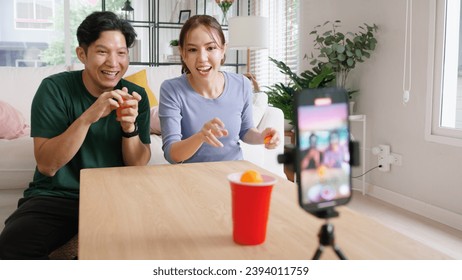 Adult influencer r asia people vlogger record viral video vlog page live fun game beer ping pong ball throw cup on  reel   social media trendy joy side hustle for young couple - Powered by Shutterstock