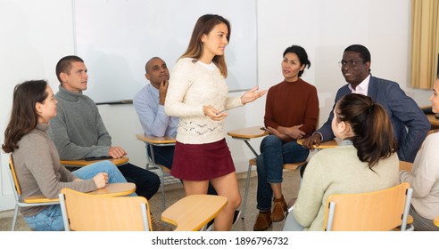 Adult lecturer talking to students during seminar