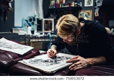 Adult male artist draws a picture of a pencil