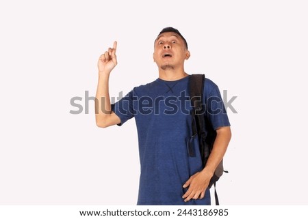 Adult male, Asian student showing happy expression while pointing upwards with bag