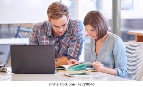 Adult Male And Female Business Partners Busy Working In Office