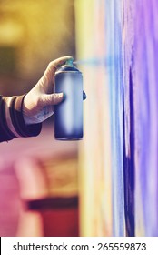 Adult Male Graffiti Artist Paint Spraying The Wall, Urban Outdoors Street Art Concept, Toned Image With Selective Focus