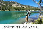Adult Male Hiker Fishing High Alpine Lake With Mountain Background