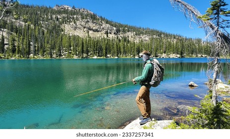 Adult Male Hiker Fishing High Alpine Lake With Mountain Background - Powered by Shutterstock