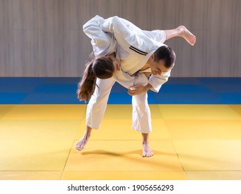 Adult Male Judoka Throwing Young Female Judo Girl With Hip Throw