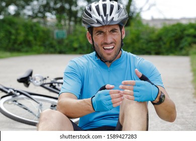 adult male nursing sore knee after falling from bicycle - Powered by Shutterstock