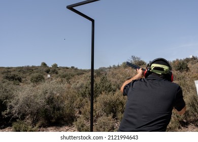 An adult man is about to shoot a clay pigeon during a skeet shooting contest. Concept of sport.