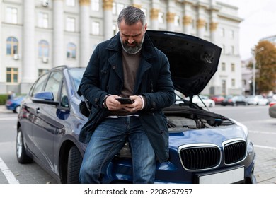 Adult Man Calls Technical Support For Car Repair Next To A Broken Car With An Open Hood