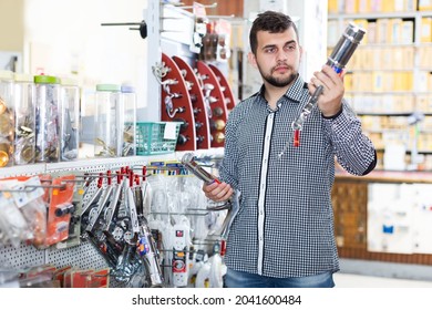 Adult man choosing new glue gun in houseware store